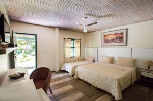 圣若昂-德雷维拉博纳比塔科洛旅馆的一间卧室配有两张床、一张桌子和一张沙发