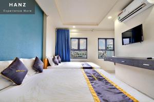 胡志明市HANZ Minh Thu Hotel Tan Binh的酒店客房设有两张床和一台平面电视。
