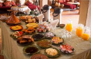 梅尔祖卡Riad family的一张桌子,上面放着一大堆食物和橙汁