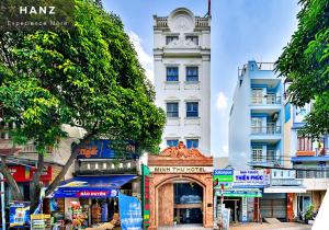 胡志明市HANZ Minh Thu Hotel Tan Binh的一座高大的白色建筑,有钟楼