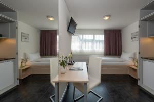 圣加仑加尼罗思丽酒店的客厅配有桌椅和床