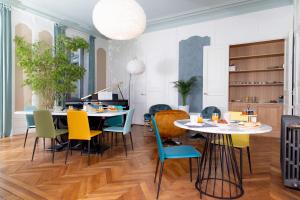 拉弗雷切La Parenthèse Fléchoise, Chambre Agathe的用餐室配有2张桌子和五颜六色的椅子