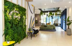 昂热Odalys City Angers Centre Gare的办公室大厅,带绿色植物的墙壁