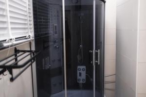 拉各斯Gerdette Luxury Apartment的浴室里设有玻璃门淋浴