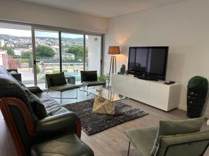 比索达雷加PMDOUROVALLEY的客厅配有电视、沙发和椅子