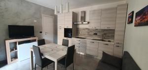 奥尔巴萨诺La Maison di Aurora的厨房配有桌椅和电视。