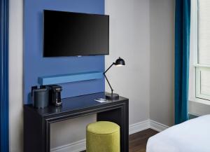 多伦多维多利亚酒店的一间卧室配有书桌、电视和凳子