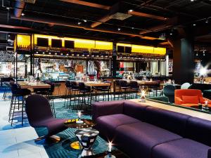 哥德堡斯堪迪克欧罗巴酒店的餐厅设有紫色长沙发和桌椅