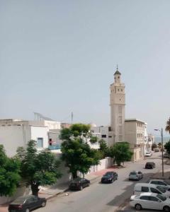 突尼斯Grand appart. Carthage Salammbô的钟楼前有车辆停放的街道