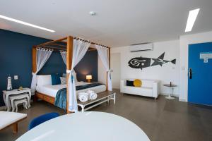 嘎林海斯港Kembali Hotel Porto de Galinhas - Adults Only的一间卧室配有一张床、一张桌子和一张床
