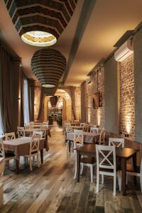 克瓦雷利Hotel Piano Kvareli的餐厅设有木桌、椅子和砖墙