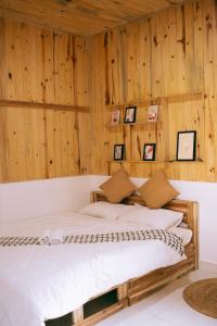 大叻Là Lá La Home的木墙客房的一张床位