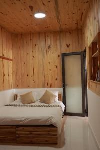 大叻Là Lá La Home的一间卧室配有一张木墙床