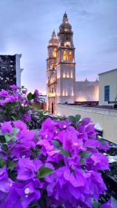 坎佩切玛雅阿金佩赫酒店的钟楼前方有紫色花