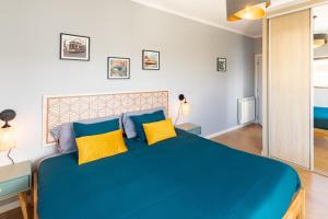 法蒂玛Modern 3 bedrooms 3 bath apartment 5 minutes walk from the Santuary的一间卧室配有一张带黄色枕头的大型蓝色床
