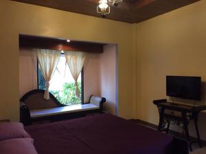 Bang Pahan甜蜜度假酒店的一间卧室设有一张床和一个带电视的窗户。