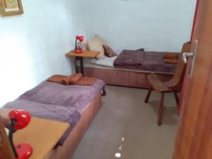 彼得罗波利斯Casa condomínio paz的客房设有两张床、一张桌子和一把椅子。