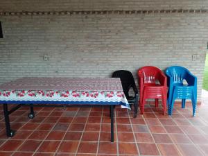 卡库佩Mi Refugio La Herencia的砖墙前有四把椅子和一张桌子