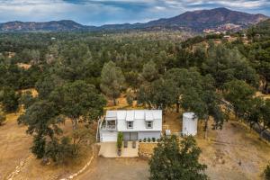 马里波萨Mariposa Home with Furnished Patio and Sierra Mtn Views的树林中白色房子的空中景色
