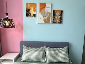 马西urban sea view home 2bed studio的一间设有一张床的房间,墙上挂着一些图片
