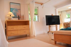 CalibishieBlue Whale Villa - Deluxe Suite的卧室配有梳妆台和平面电视。