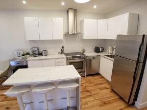 蒙特利尔3 bedroom near Olympic Stadium的厨房配有白色橱柜和不锈钢用具
