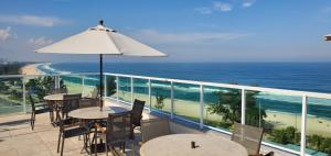 里约热内卢Atlantico Sul Hotel的一个带桌椅的海景阳台