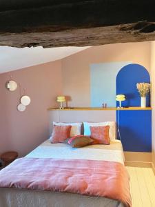 里摩日Maison d'hôte Les Allois的一间卧室配有一张带色彩缤纷枕头的大床