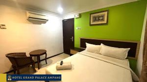 安邦Hotel Grand Palace Ampang的酒店客房,设有床铺和绿色的墙壁