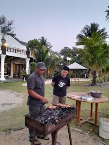 BantenKeraton Krakatoa的两个男人在烤架上做饭