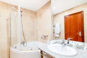 蓬费拉达庞费拉达广场酒店的浴室配有水槽、淋浴和浴缸。