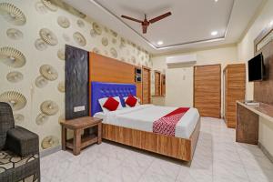 贡土尔OYO Flagship Hotel Aditya Grand Inn的一间酒店客房,配有一张床和一台电视
