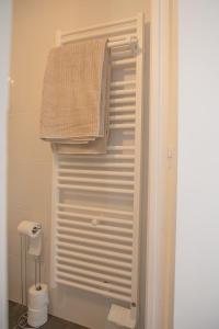 圣纳泽尔Le Marais - Appart'Escale的浴室的毛巾挂在门上