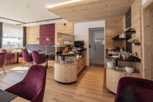 索尔登加尼柔丝迪卡酒店的厨房铺有木地板,配有紫色椅子