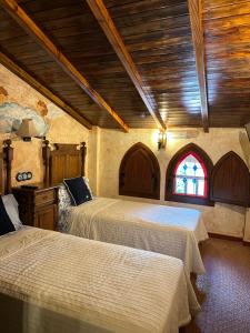 阿罗约弗里奥Casa Rural Ermita Santa Maria de la Sierra的一间卧室设有两张床和彩色玻璃窗。