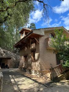 阿罗约弗里奥Casa Rural Ermita Santa Maria de la Sierra的一座古老的砖砌建筑,上面设有阳台
