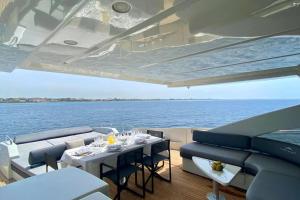 马里纳·迪·波迪斯科Exclusive Yacht - Azimut 86s的船上的用餐室,配有桌椅