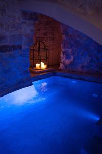 奥斯图尼Suite Le Grotte的一个大游泳池,在房间内有蜡烛