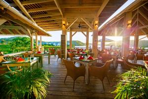 GaynorsEscape at Nonsuch Bay Antigua - All Inclusive - Adults Only的一间铺有木地板并配有桌椅的餐厅