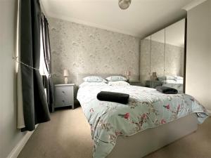 利兹Cheerful two-bedroom townhouse near Leeds and York的一间卧室配有一张床和一面大镜子