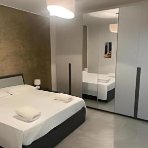 奥尔巴萨诺La Maison di Aurora的卧室配有一张白色大床和镜子