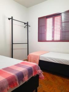 巴拉博尼塔Casa da Vó Nair的客房设有两张床和一扇窗户。