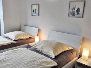 科布伦茨Gästehaus Koblenz的配有两张床铺的房间,配有两盏灯