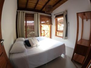 巴拉格兰德Vila Bombaça - 100 metros da praia的卧室配有白色的床和2扇窗户。
