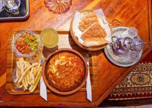 梅克内斯Riad Sibari的一张木桌,上面放着一盘食物和薯条