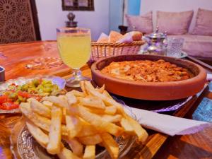 梅克内斯Riad Sibari的一张桌子,上面放着一盘薯条和一碗食物