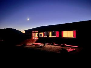 瓦迪拉姆Bedouin Nights Camp的建筑的侧面有红色窗户
