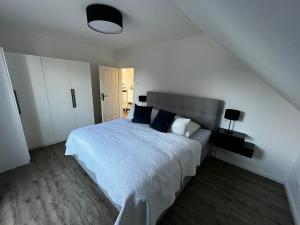 柏林Hochwertiges Haus mit Garten mit guter Anbindung的白色卧室配有蓝色枕头的床