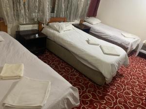 AltındağAltunlar erkek ögrenci yurdu的酒店客房,设有两张床和两张桌子