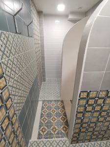 维尔纽斯Bar-celona的浴室铺有瓷砖地板,设有步入式淋浴间。